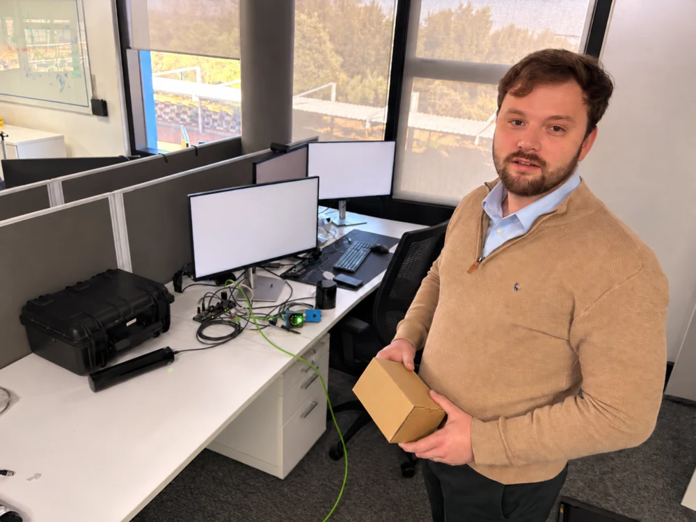 Justin beside an office workbench, with the background person removed