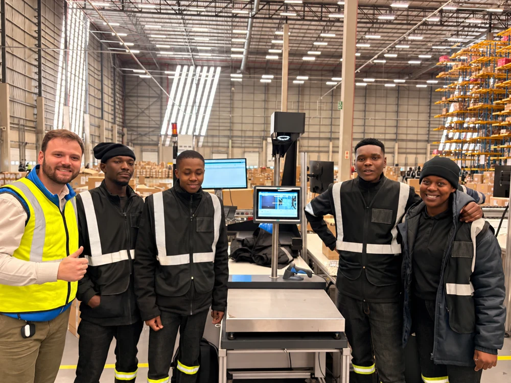 Justin with four people in a warehouse, with jacket logos removed